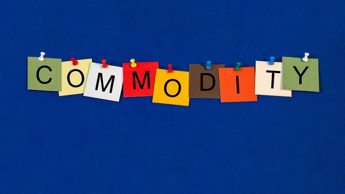 The image displays the word COMMODITY spelt out on colourful note cards pinned to a blue background