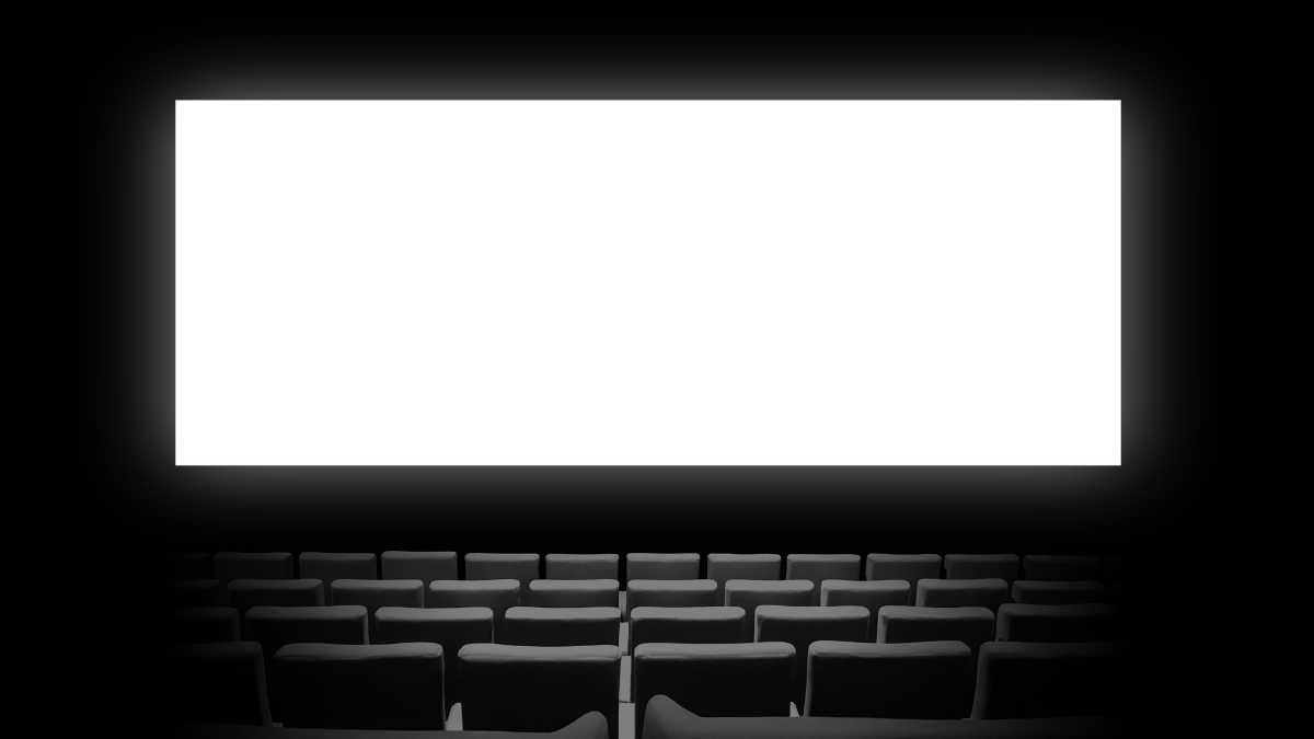 A dark cinema with rows of empty seats and a blank screen