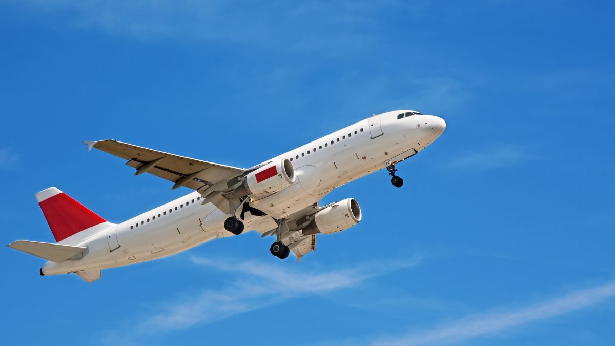 a commercial airliner in mid-flight against a clear blue sky