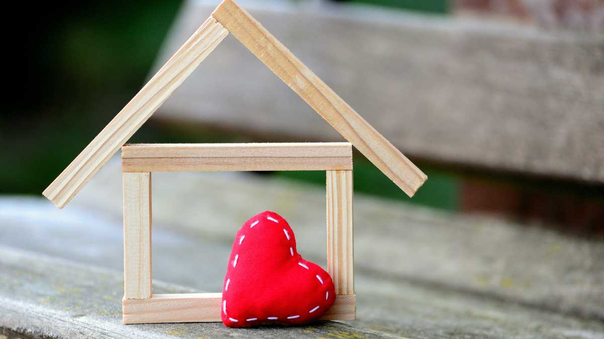 A wooden house frame with a red heart inside.