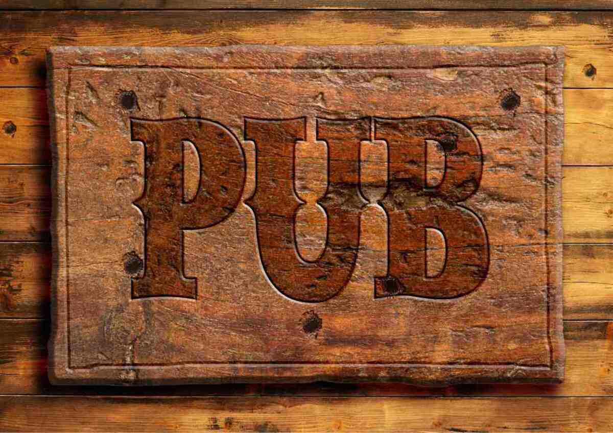 Carved wooden "PUB" sign on a plank background.