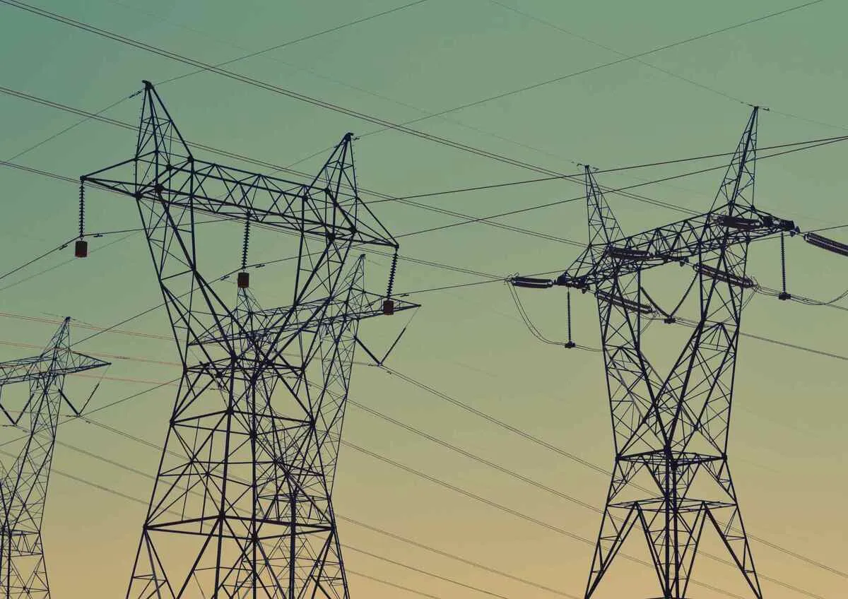 Power transmission towers against a dusk sky, representing energy infrastructure