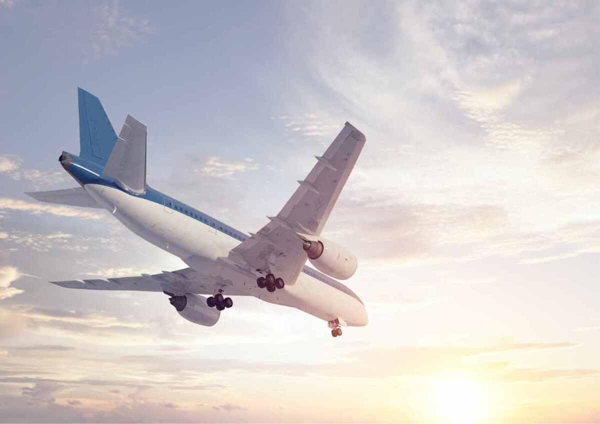 Airplane soaring in the sky at sunset