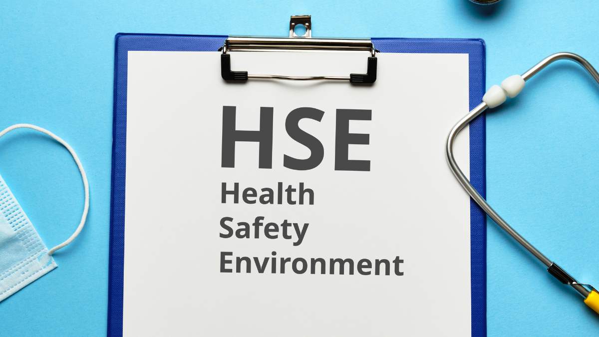 a clipboard with a piece of paper titled HSE Health Safety Environment on a bright blue background