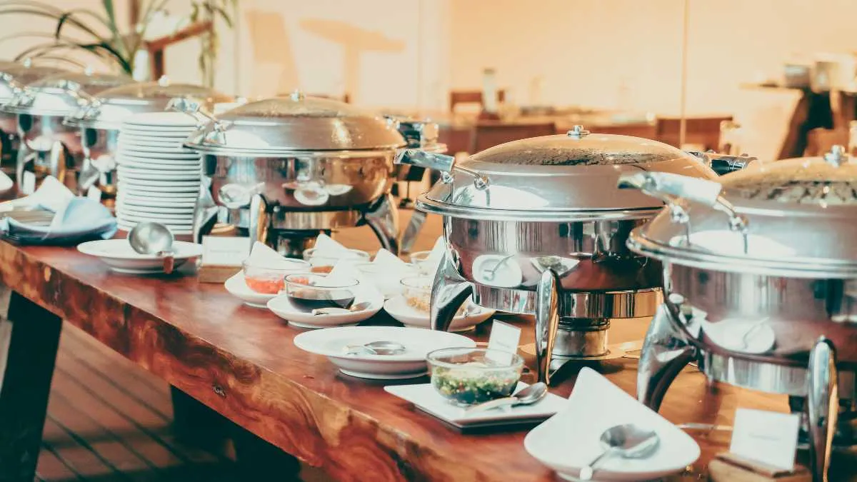 Buffet line with chafing dishes and stacked plates