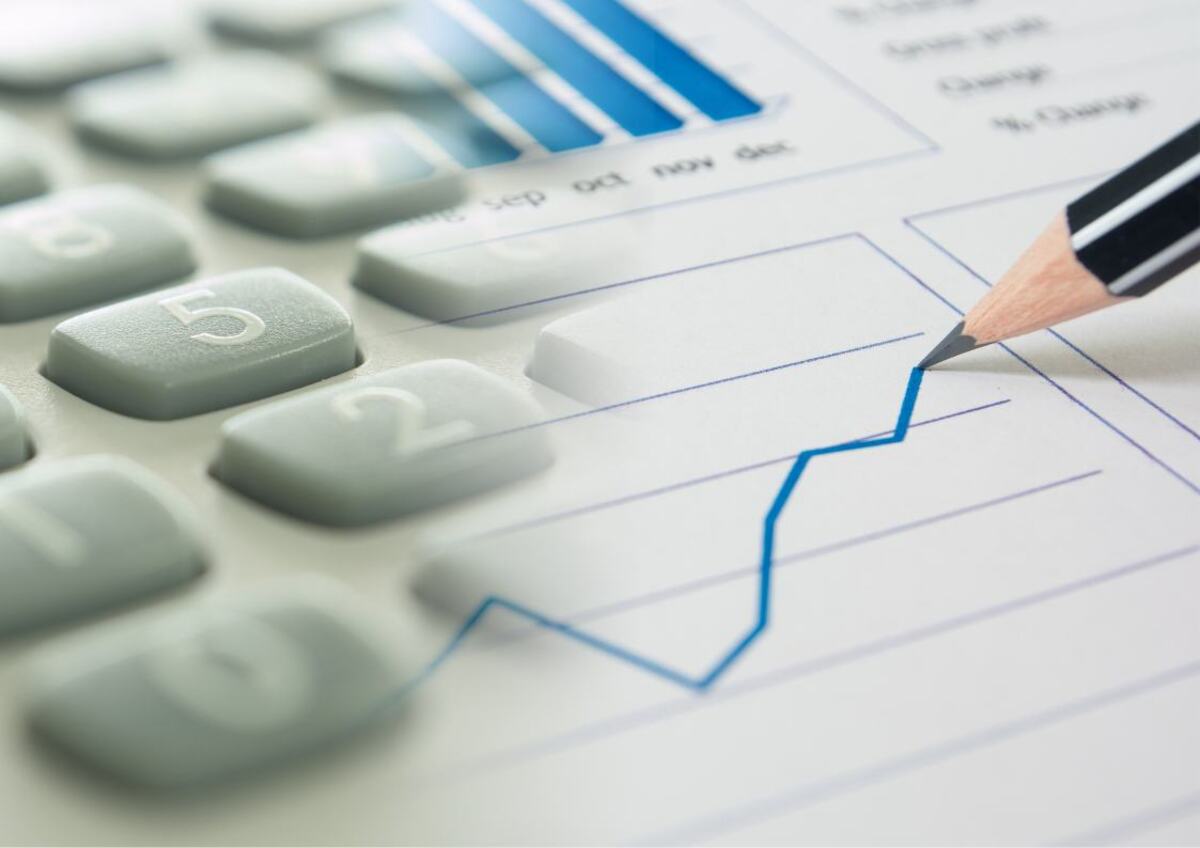 Close-up of a graph, pencil, and calculator, indicating financial analysis.