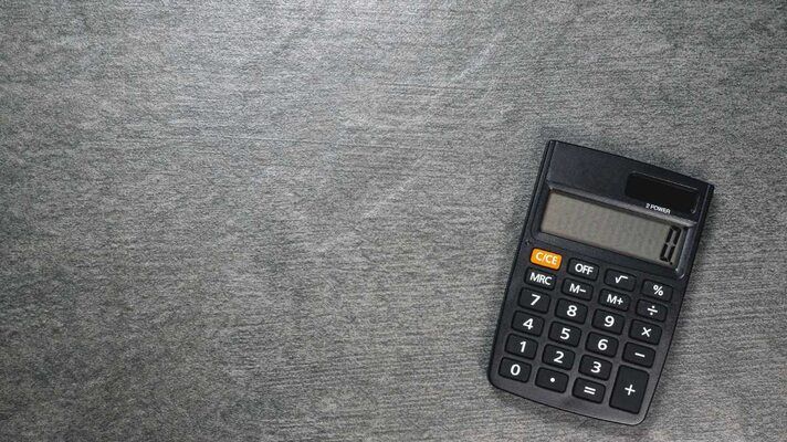 A black calculator on a grey textured background