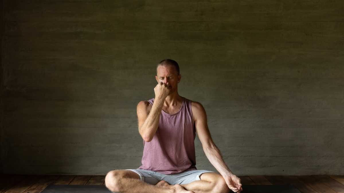 Yoga man poses practising breathing exercises