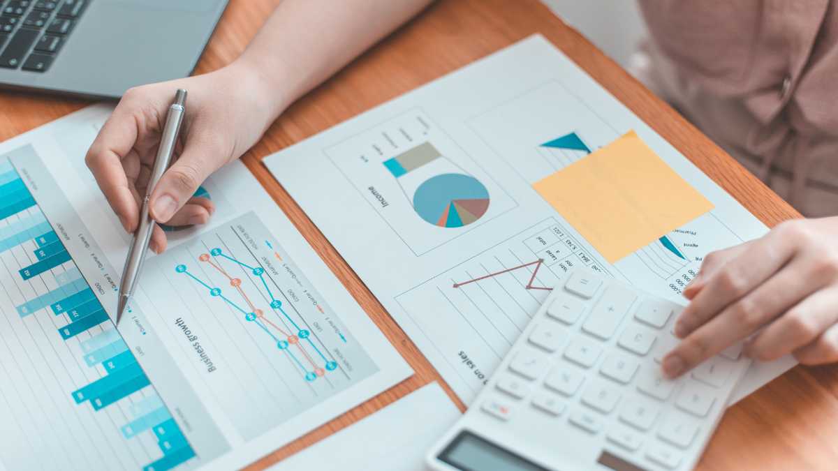 Person calculating finances with charts and a calculator