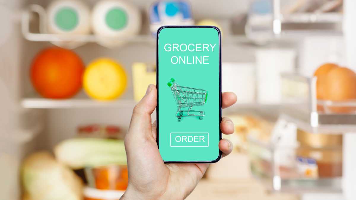 Hand-holding smartphone with grocery app on screen.