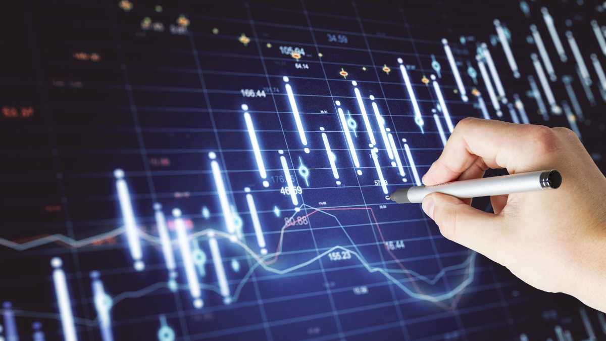 A hand noting on a trading chart