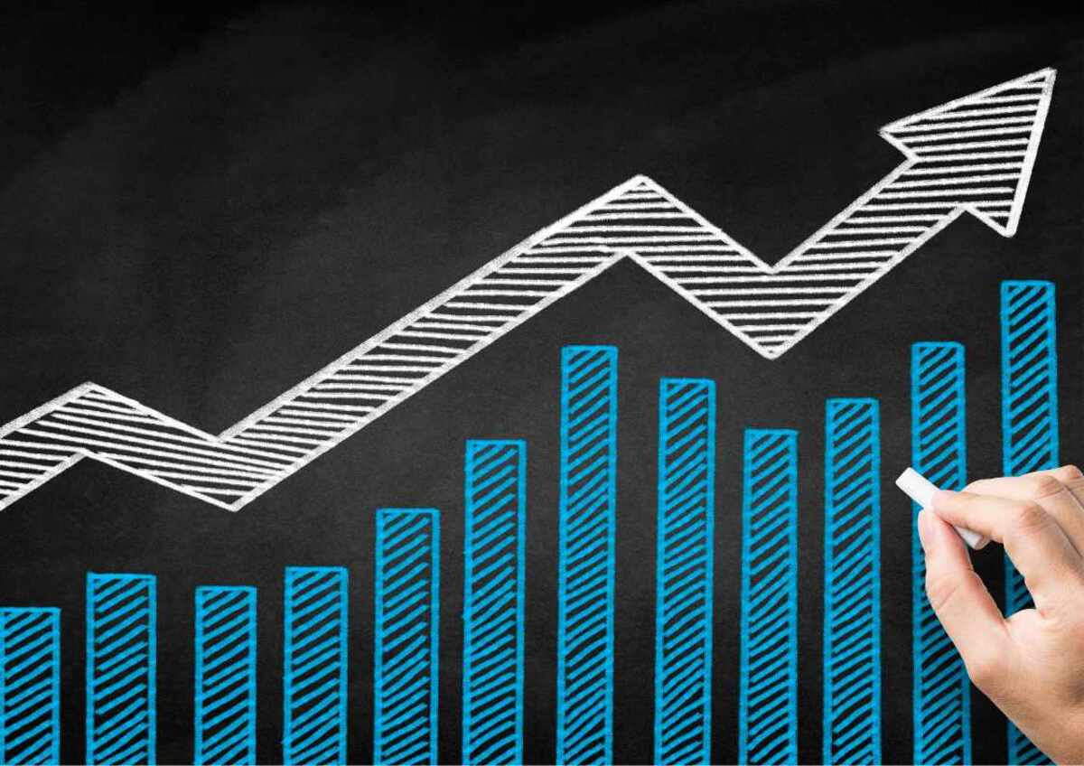 Hand drawing an ascending graph on a chalkboard