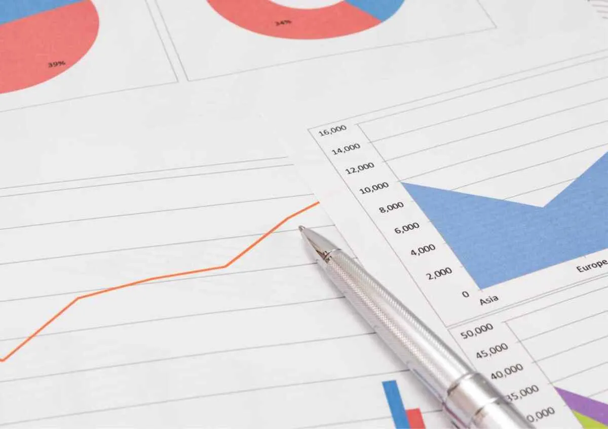 Pen on financial graphs and charts.