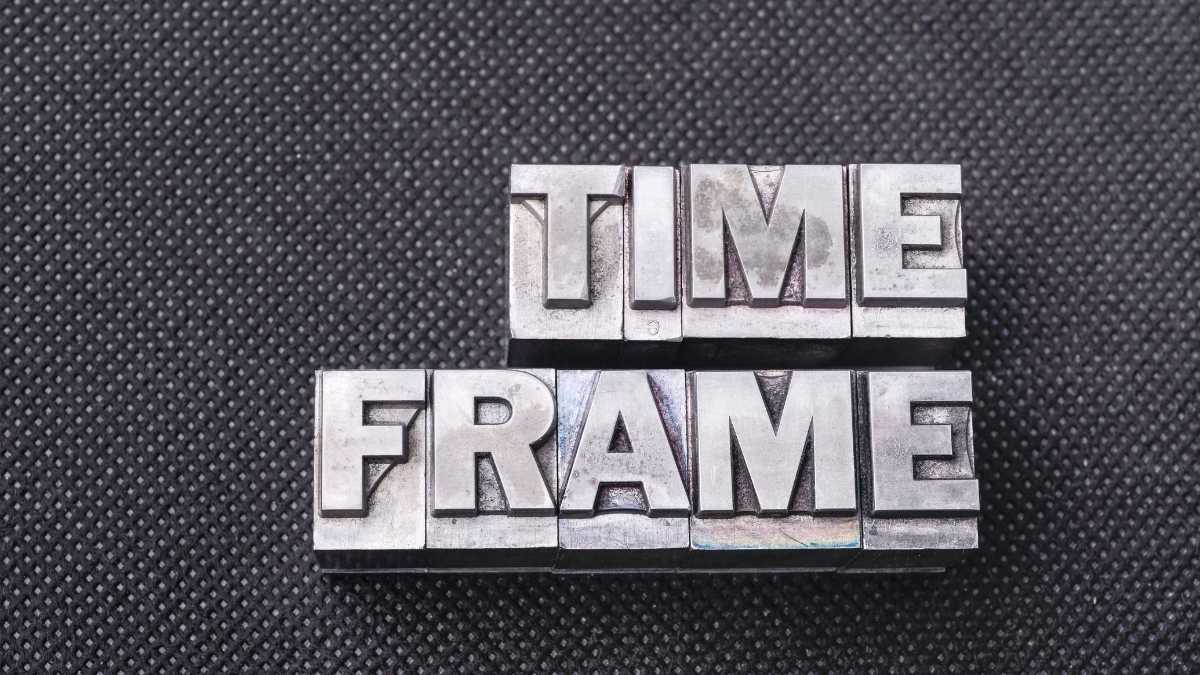 Metal typeface blocks spelling TIME FRAME on textured background