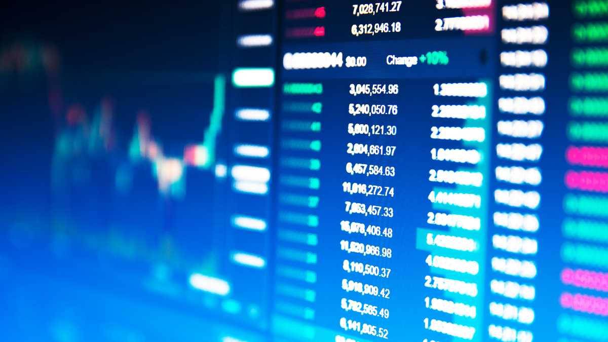 A blurred image of a financial data screen showing stock numbers and trends.