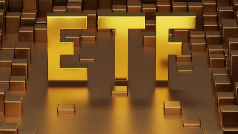 3D gold letters ETF on a background of gold bars