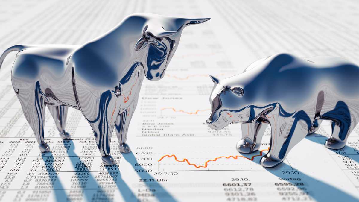 Metallic bull figures on financial documents with graphs