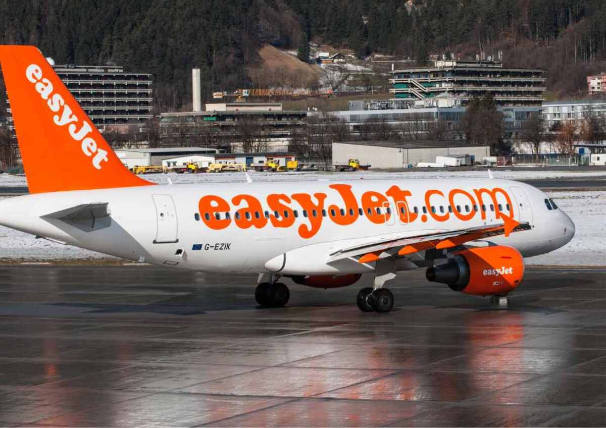 An EasyJet aircraft on the tarmac, showcasing the company's branding and website on its fuselage and engine.