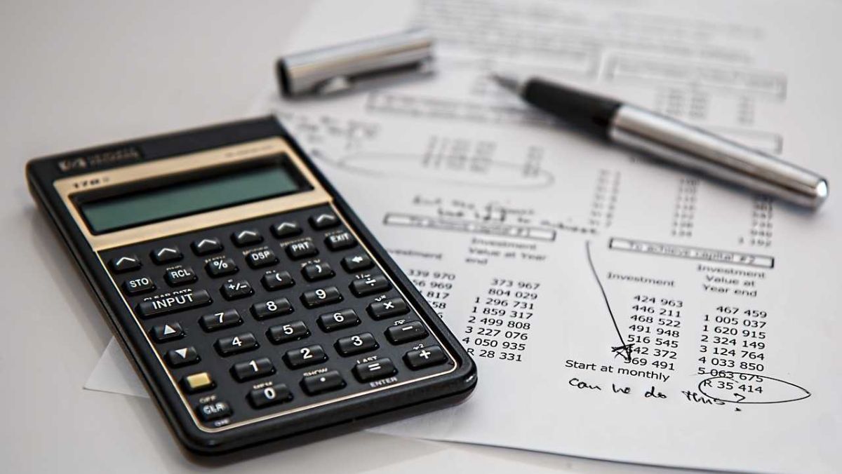 A calculator a pen and a financial statement on a table