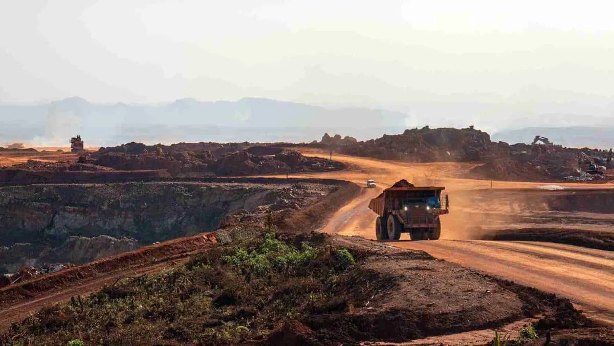 A hauling truck follows a path within the expansive mining pit