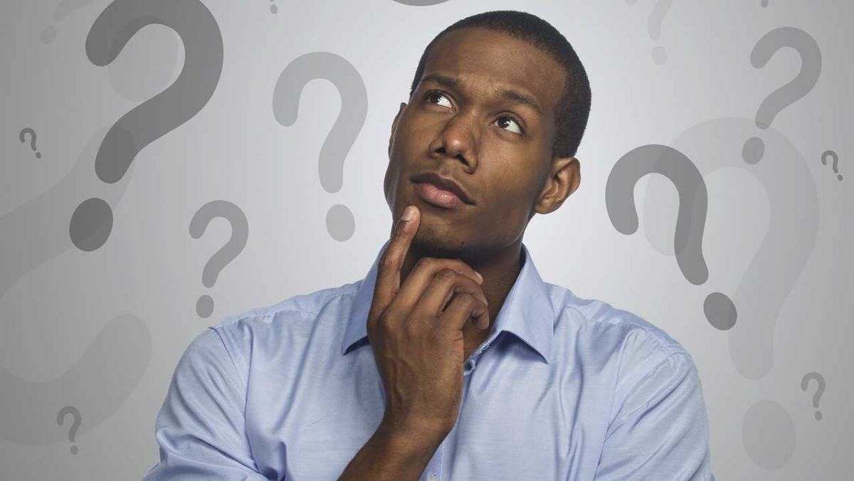 A man touching his chin while thinking, question marks on the background