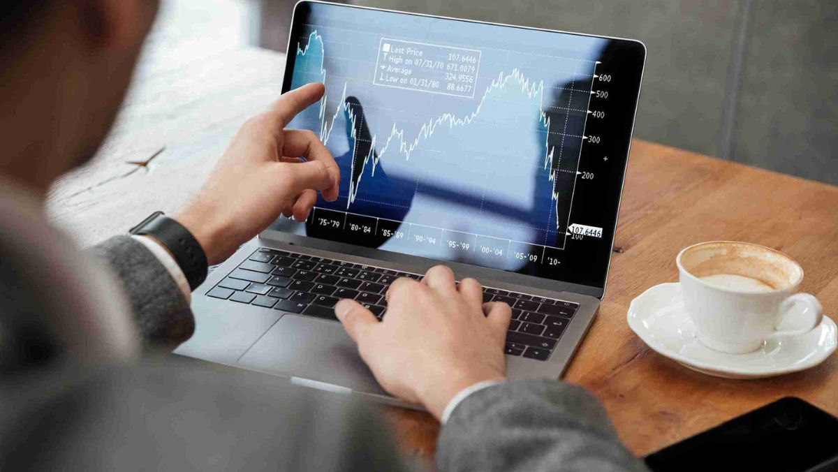 A man uses his laptop to emphasise a trading pattern