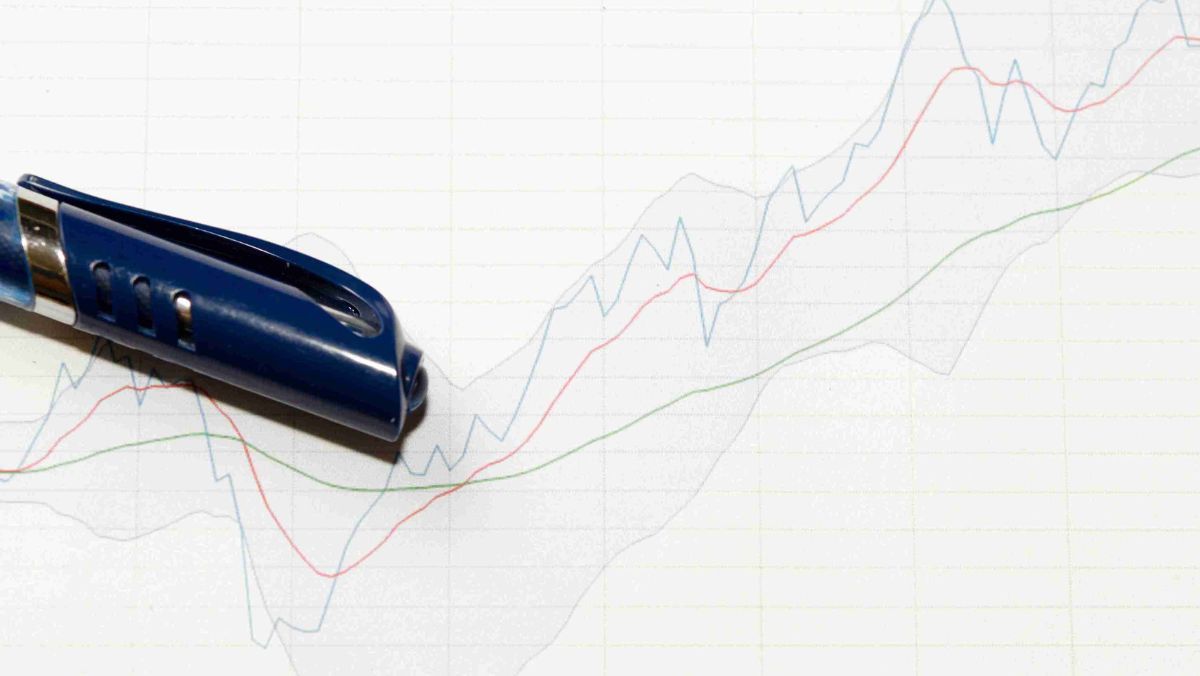 A pen resting on an analytical screen featuring multiple line graphs