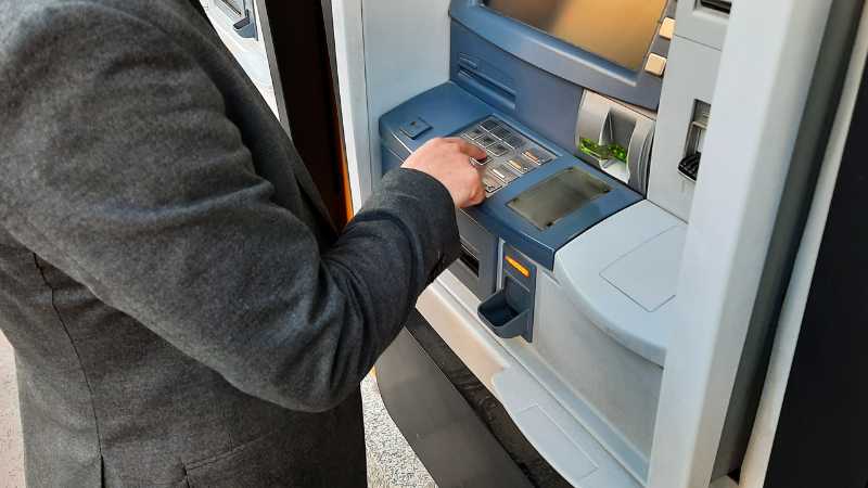 A person in a suit is using an ATM