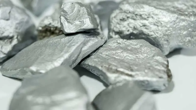 A stack of shiny silver rocks on a plain white surface