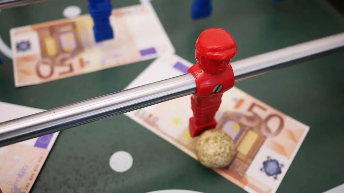 A tabletop football game with scattered money notes