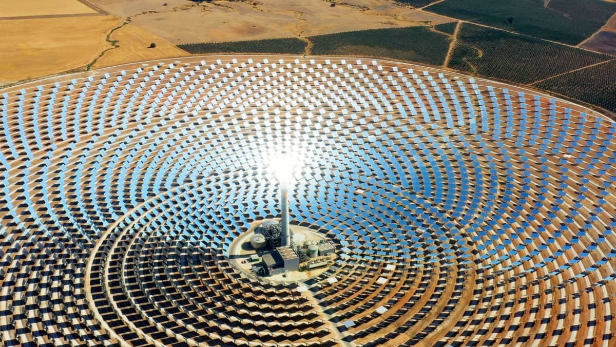 Aerial view of a solar power tower surrounded by mirror panels.