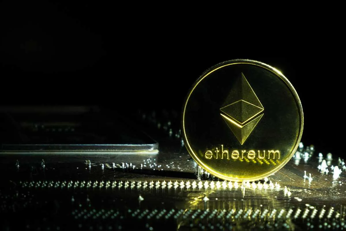 An Ethereum coin on a circuit board illuminated from the side