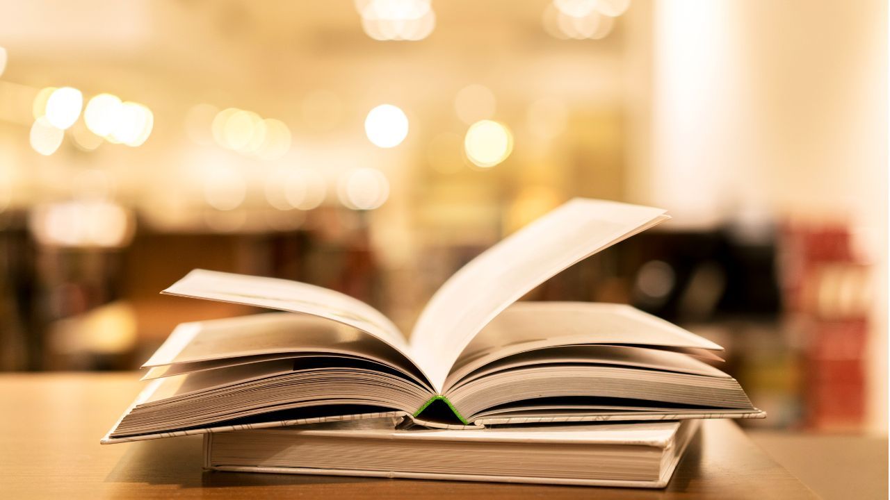 An open book on a table with a blurred warm lit background