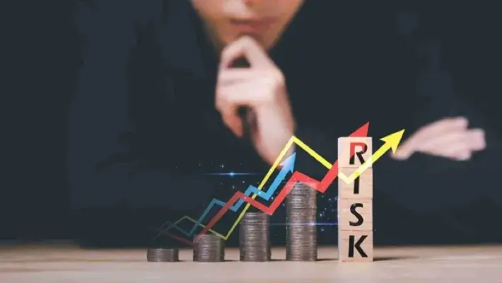 Man is making a thoughtful decision, coins stack and wooden blocks with 'risk' text are arranged vertically