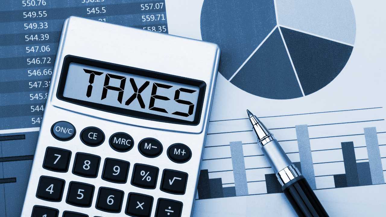 Calculator displaying  TAXES on financial charts with a pen