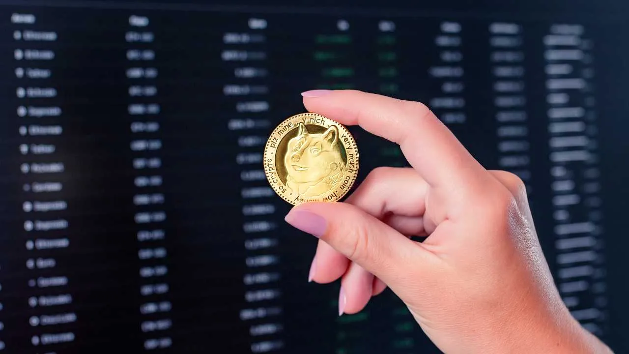 Hand holding a Dogecoin with digital trading data in the background