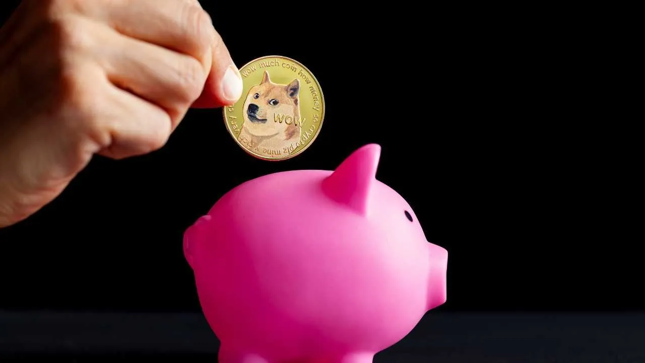 Hand inserting a Dogecoin into a pink piggy bank