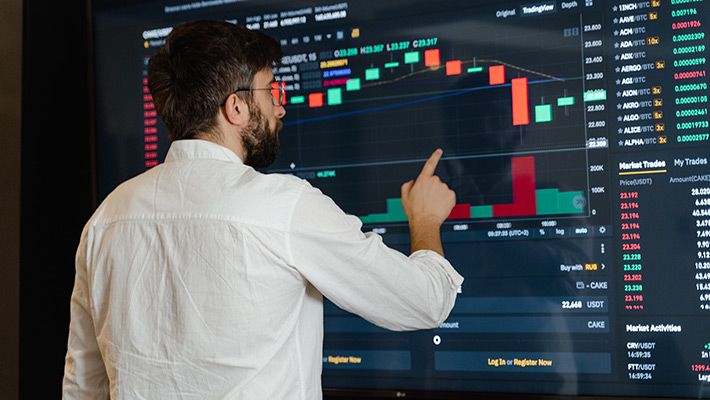 a man studying day trading on a large display