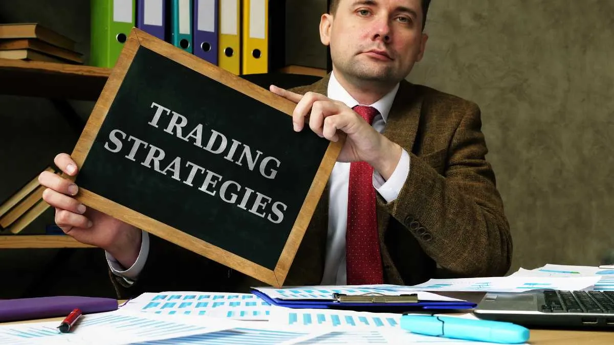 Man in suit holding a sign that says TRADING STRATEGIES