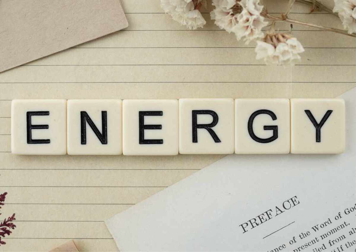 Scrabble tiles spell "ENERGY" on a lined paper background.