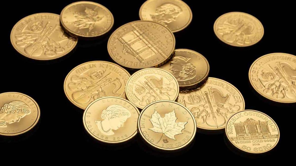 Shimmering gold coins displayed on a black flat surface