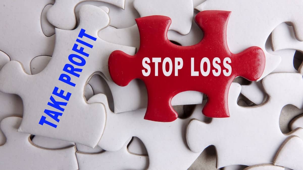 Red puzzle on a white puzzle background with text TAKE PROFIT AND STOP LOSS