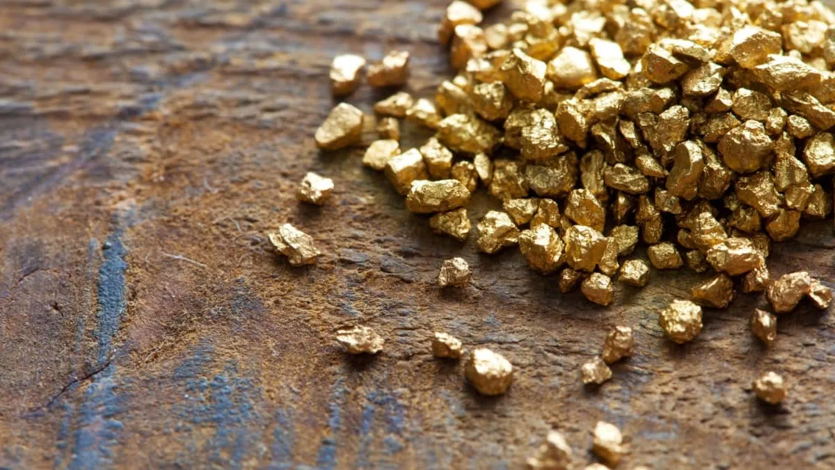 A mound of gold on an old wooden work table