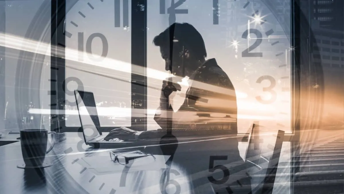 A double exposure portraying a trader diligently working and a clock ticking