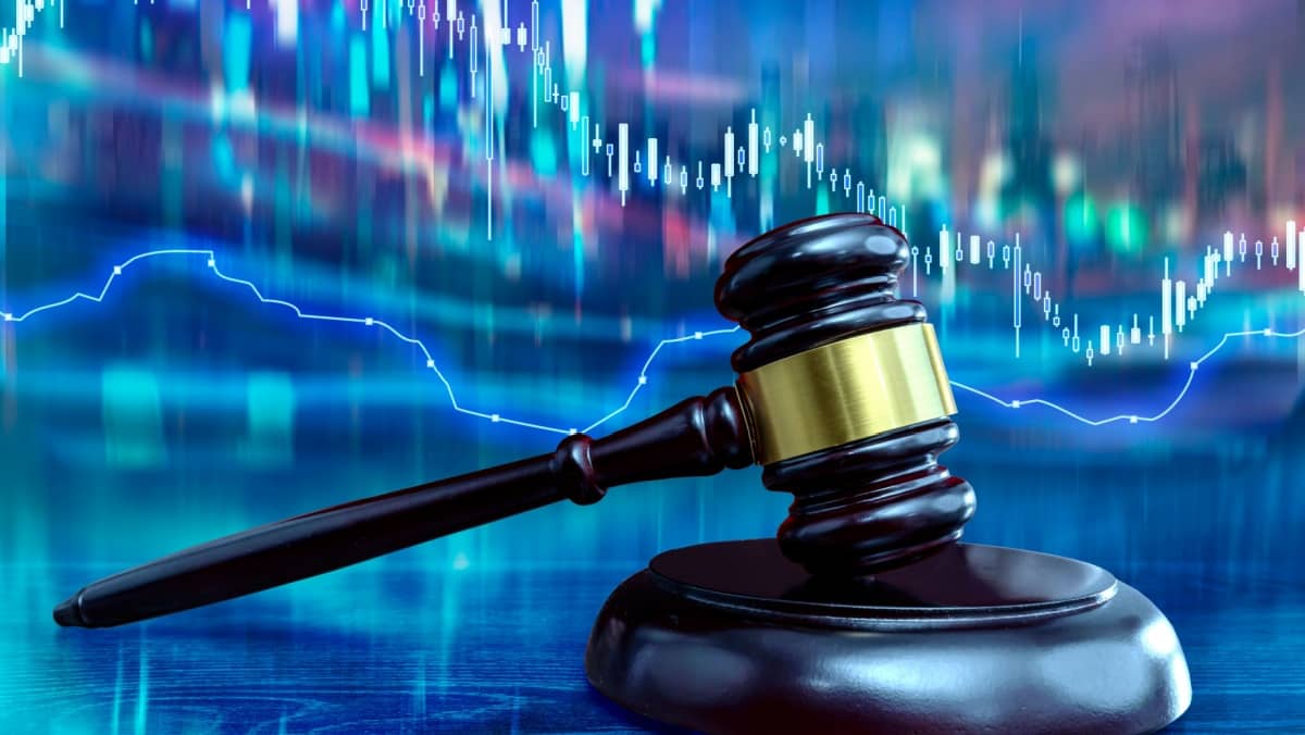 Zoomed in image featuring a judicial gavel with a trading chart as the contrasting background