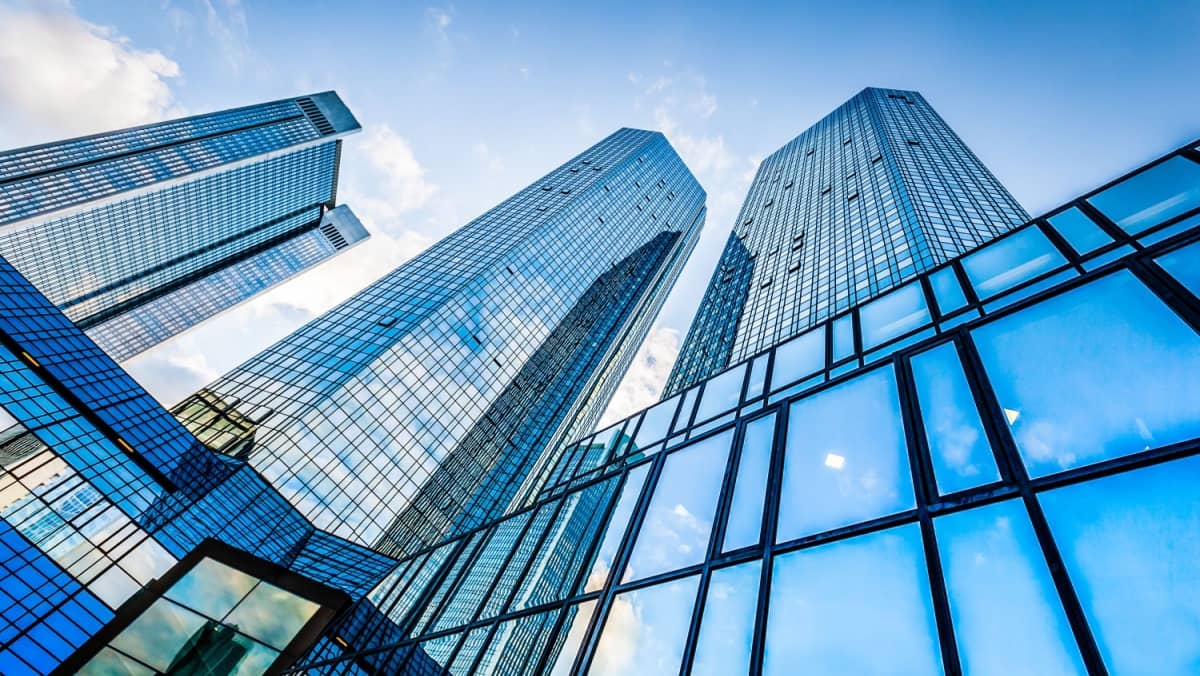 View from below capturing modern skyscrapers in the corporate district set against a clear blue sky