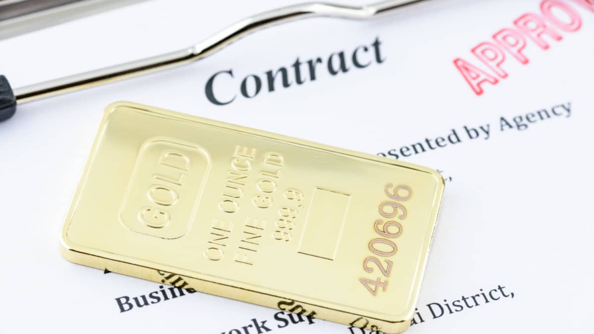 Approved contract on a clipboard accompanying genuine physical gold bullion