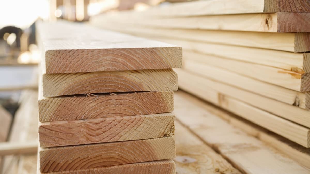 Selective focus image of stacks of lumber sitting at a construction site of a new home