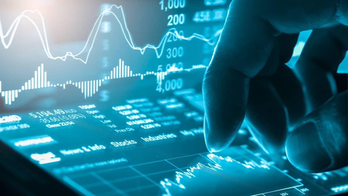 Neon style digital screen displaying stock market data with fingertips touching it