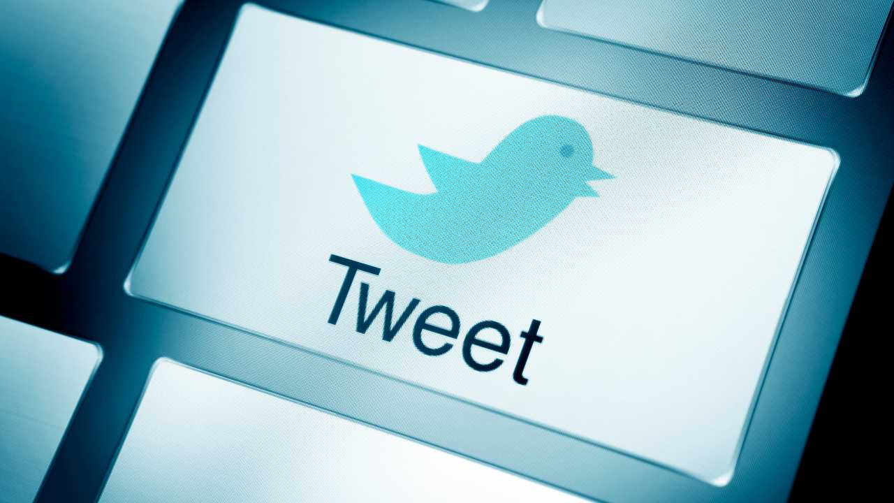  Tweet  button with Twitter bird icon on a keyboard